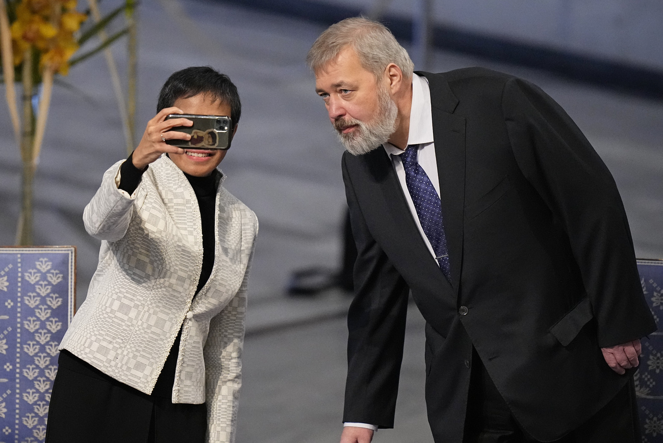 Nobel Peace Prize winners Dmitry Muratov from Russia, right, and Maria Ressa of the Philippines pose for a selfie during the Nobel Peace Prize ceremony at Oslo City Hall, Norway, Friday, Dec. 10, 2021. The Norwegian Nobel Committee cited Ressa and Muratov's fight for freedom of expression, stressing that it is vital in promoting peace.