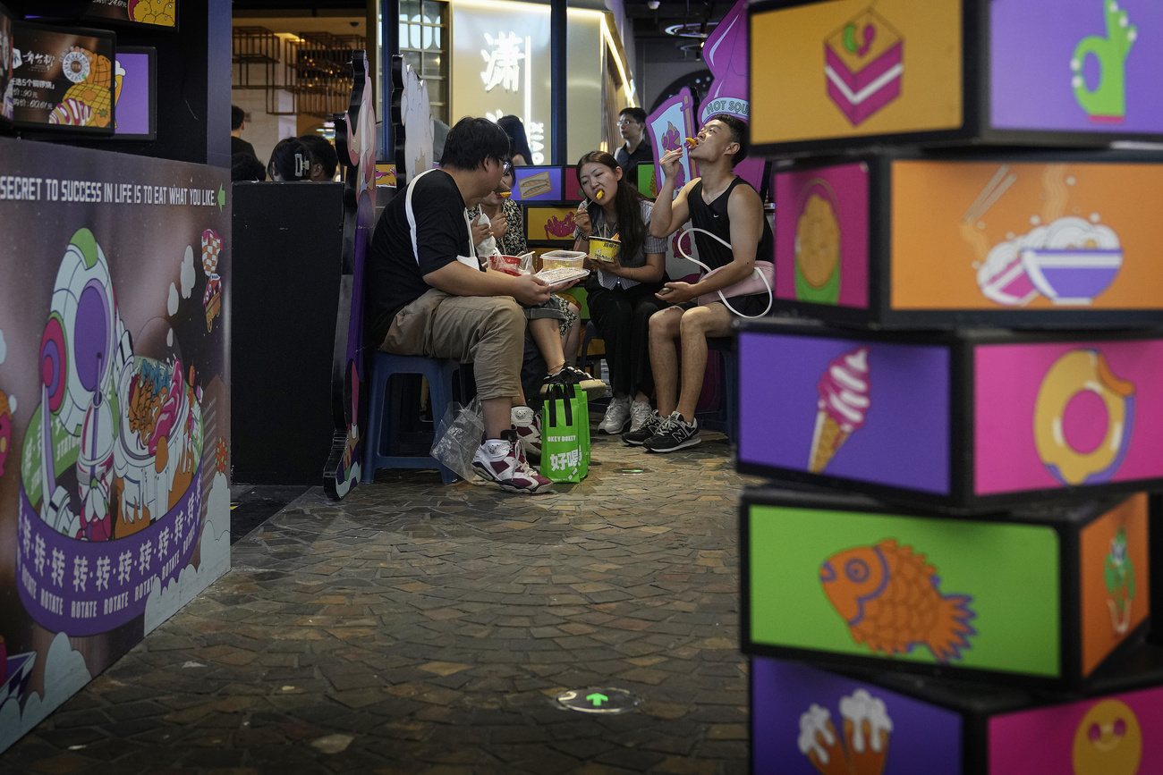 Grupo de chineses sentados à mesa e conversando