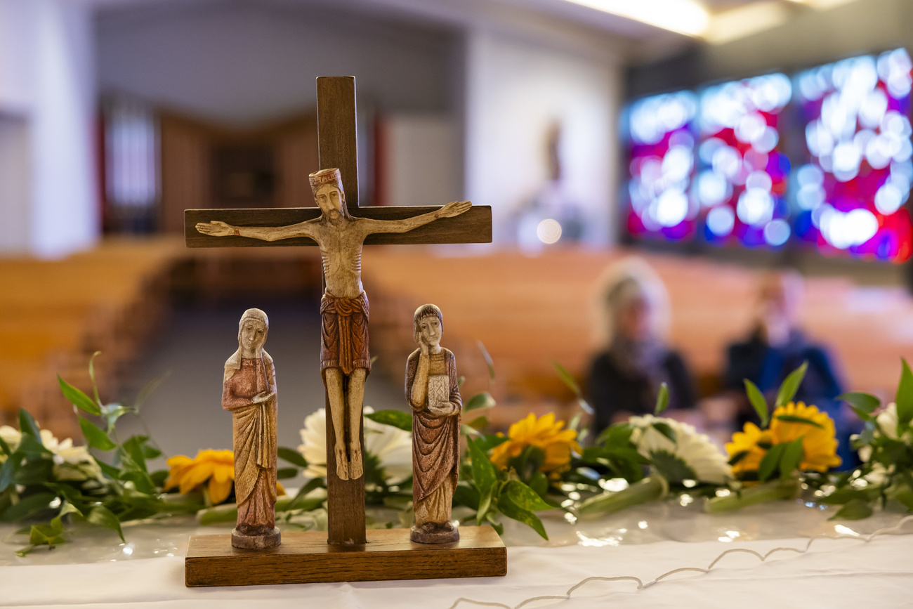croce in una chiesa con due persone sullo sfondo