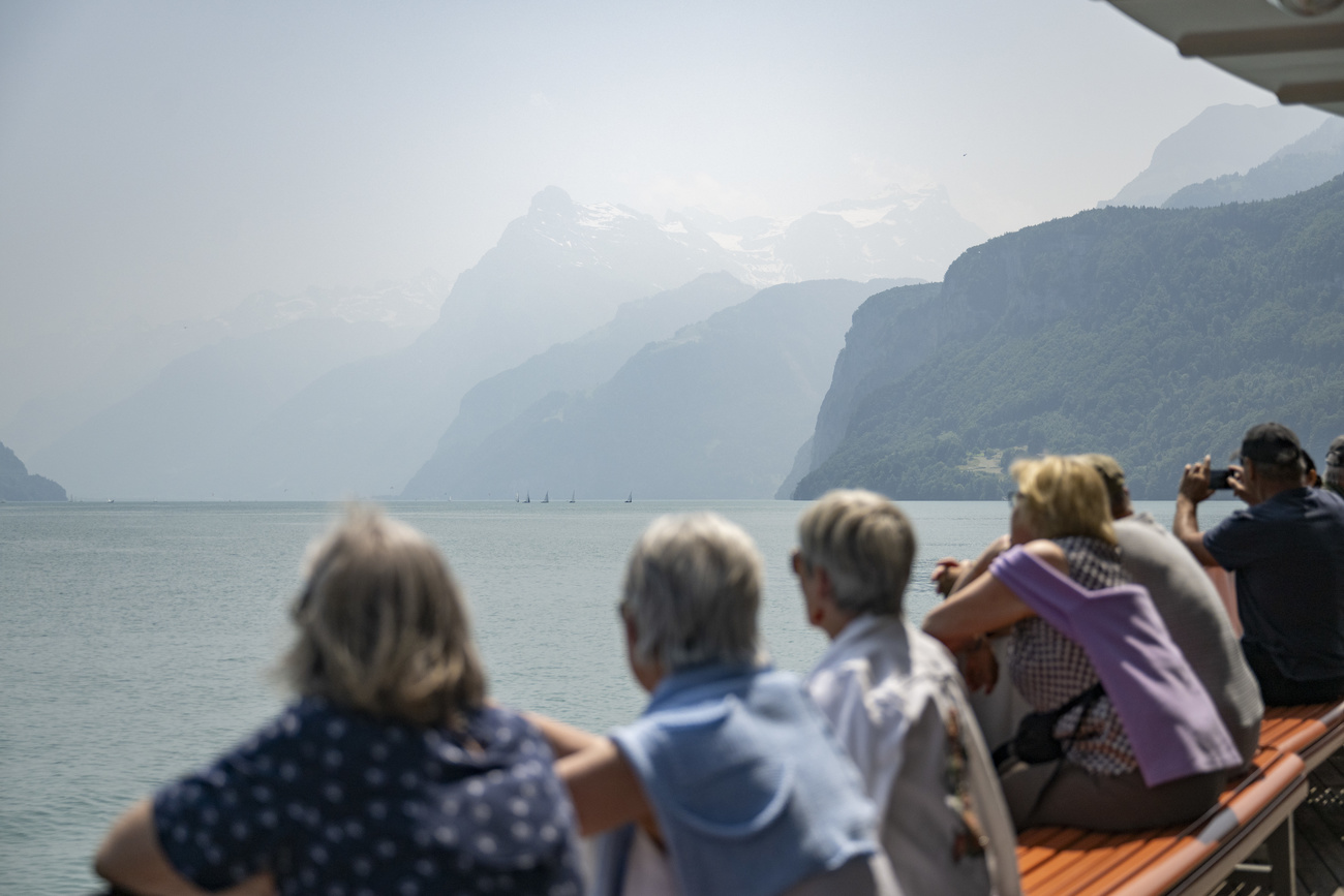 Passanti osservano l’aria offuscata dai fumi provenienti dal Canada sul lago di Uri a Brunnen.