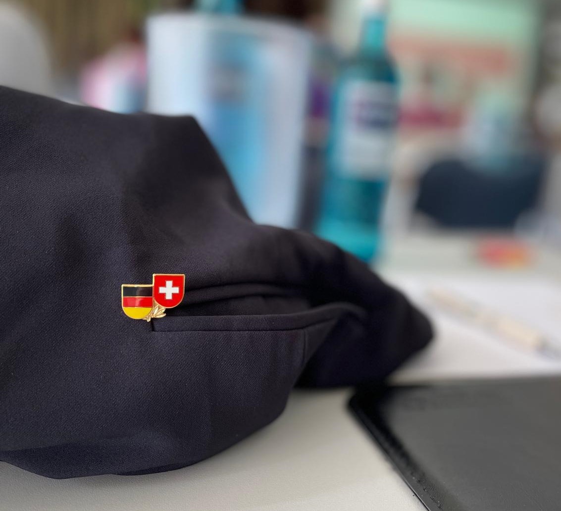 Pin mit deutscher und schweizer Flagge in der Tasche eines Blazers