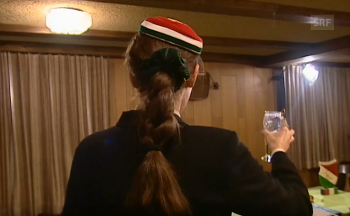Ein Mitglied der Studentinnenverbindung Kybelia hebt ihr Glas.