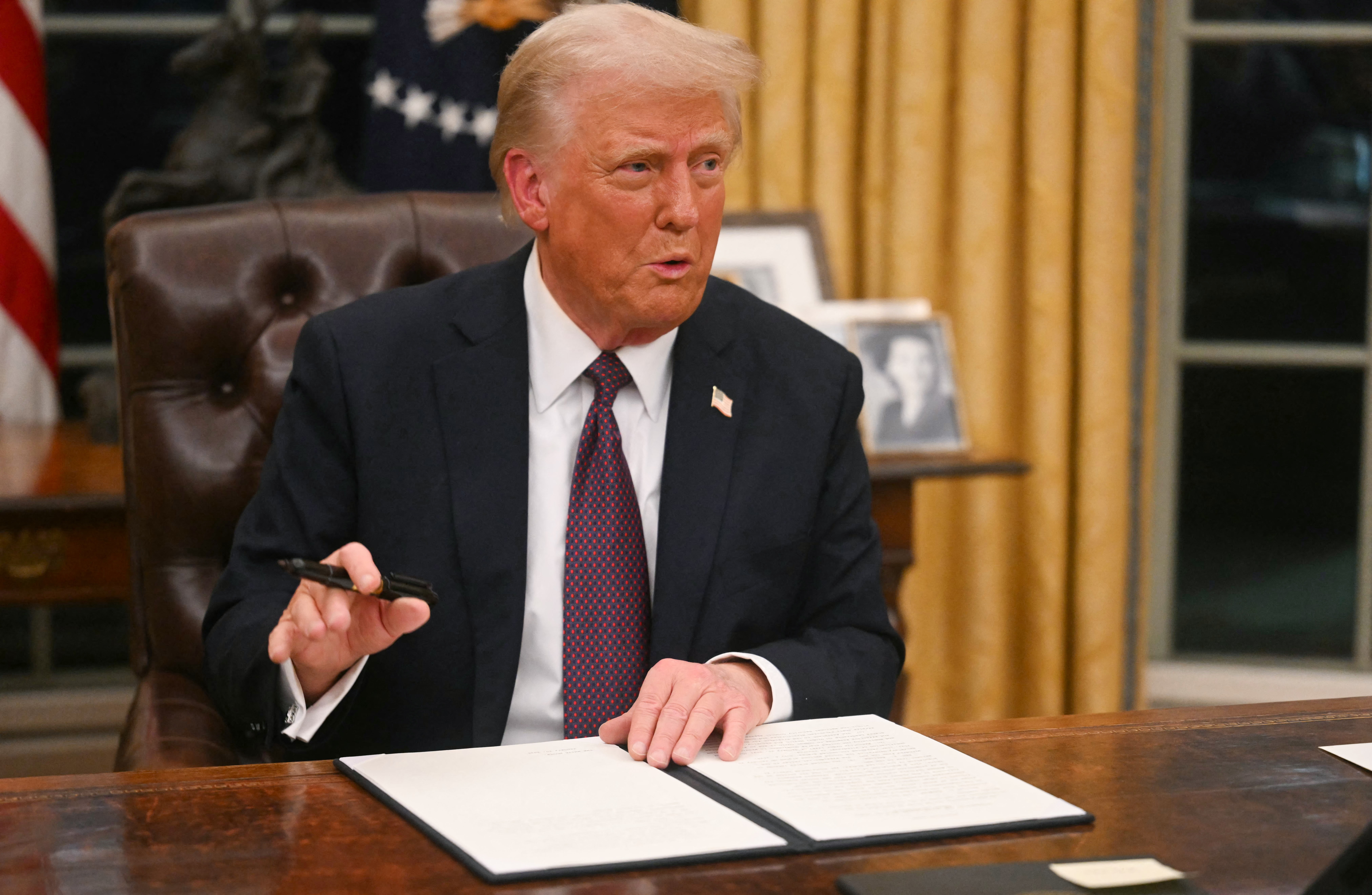 US President Donald Trump signs an executive order on the US withdrawal from WHO (World Health Organization) in the Oval Office of the White House in Washington, DC, on January 20, 2025.