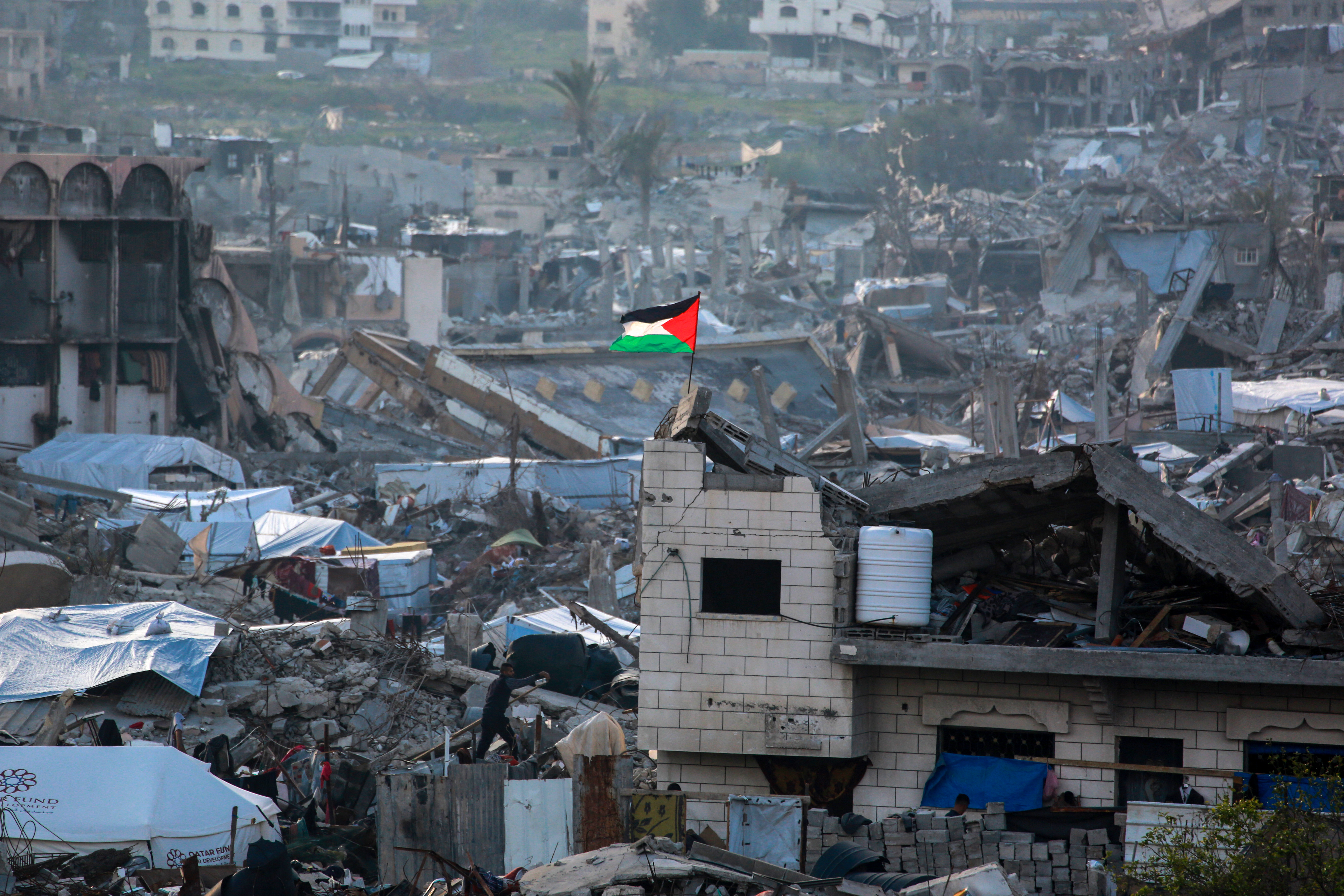 A Palestinian flag flutters amid the ruins of buildings in Beit Lahia in the northern Gaza Strip on March 4, 2025, amid the ongoing truce between Israel and Hamas.