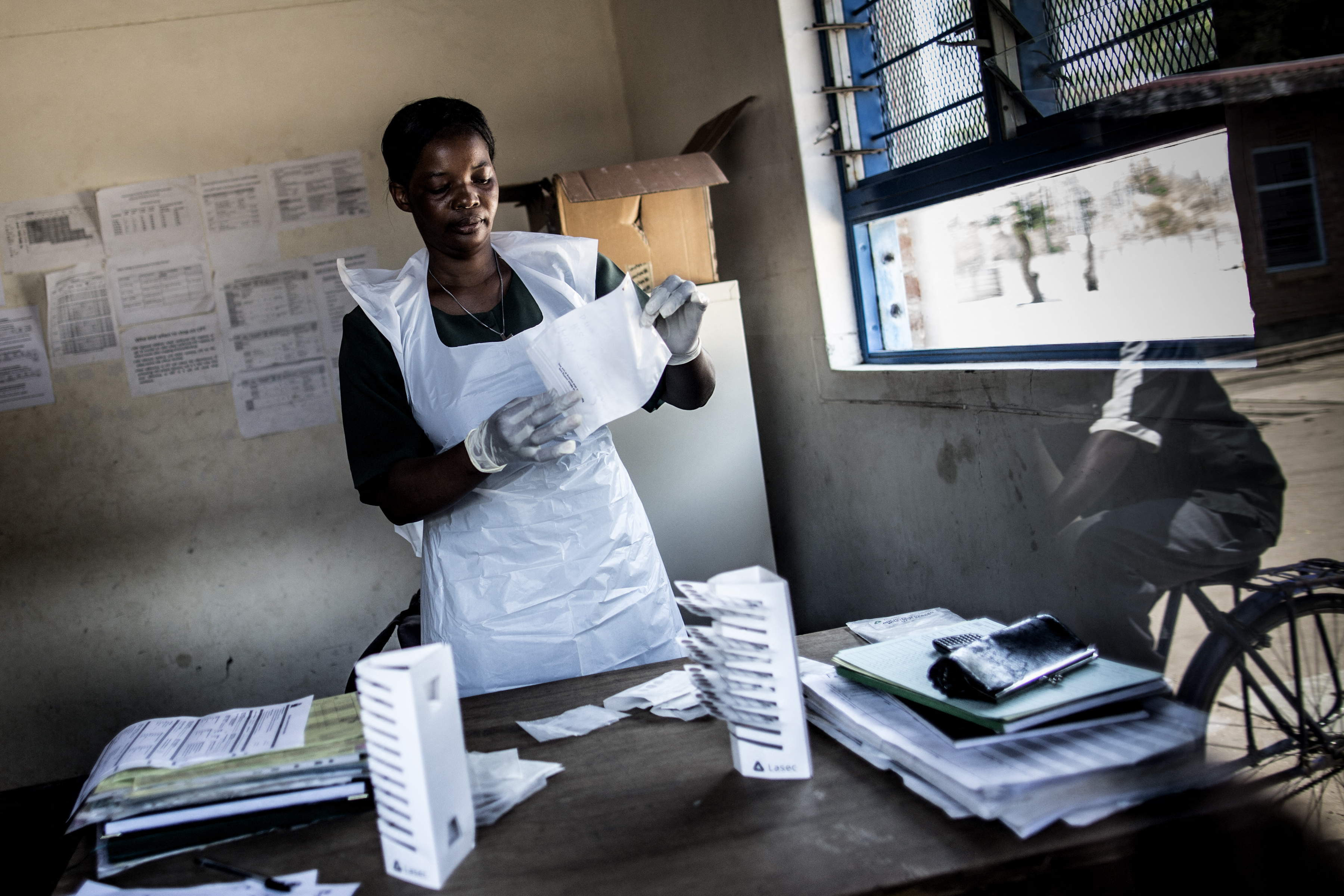 un'infermiera prepatra dei campioni di sangue in un centro sanitario in africa