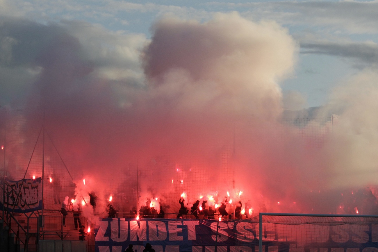 Grasshopper's supporters light smoke flares.
