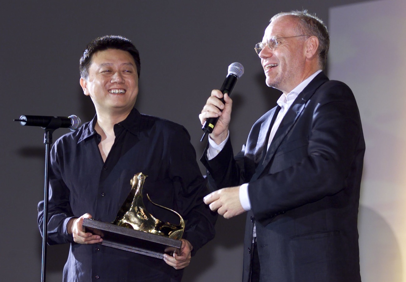 Wang Shuo holds the Golden Leopard he received for his film "Father", and thanks the resigning director of the festival, Marco Mueller (right), for his support at the 53rd Locarno Film Festival, in 2000.