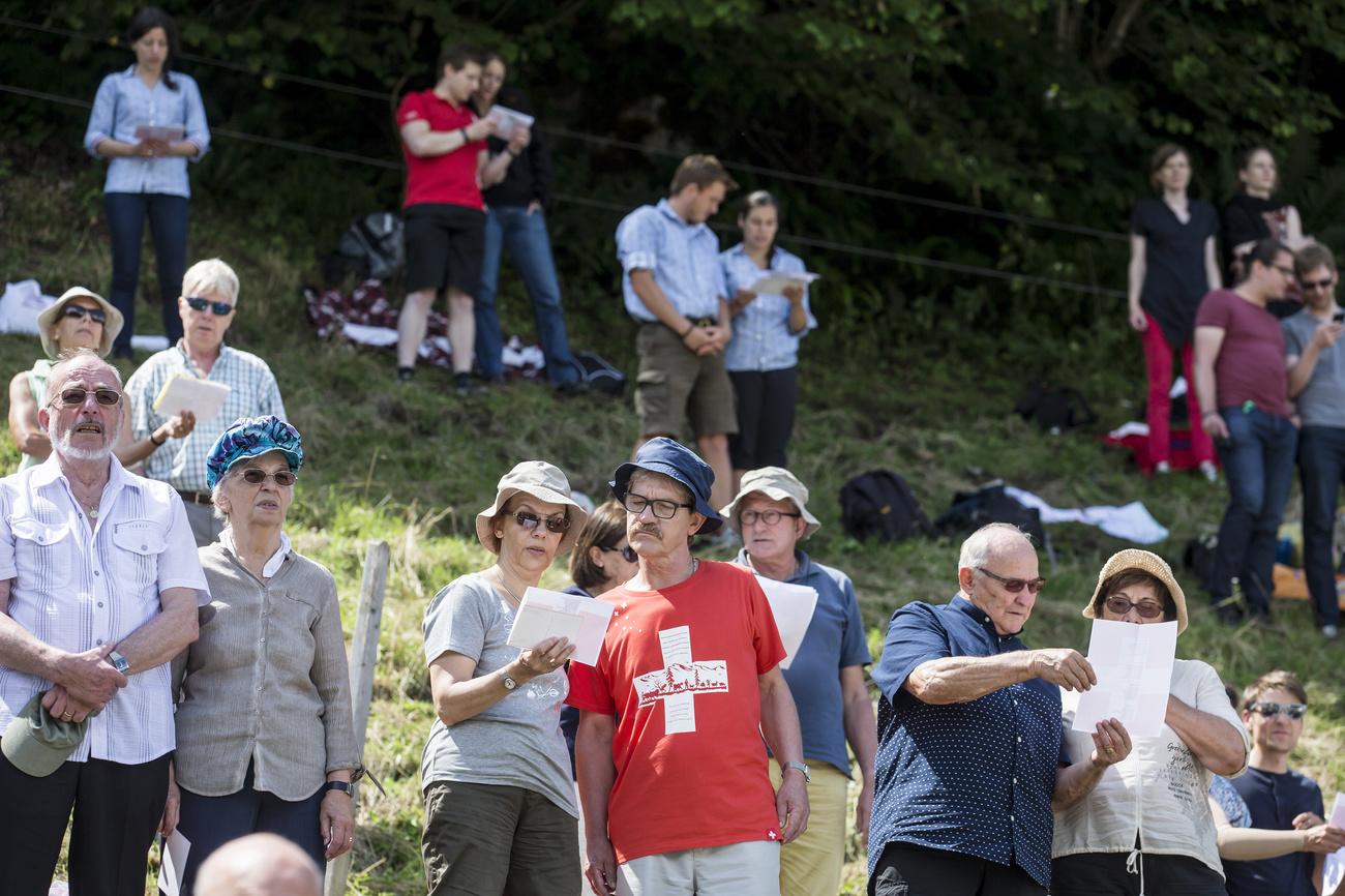 Foule en train de chanter l'hymne national suisse