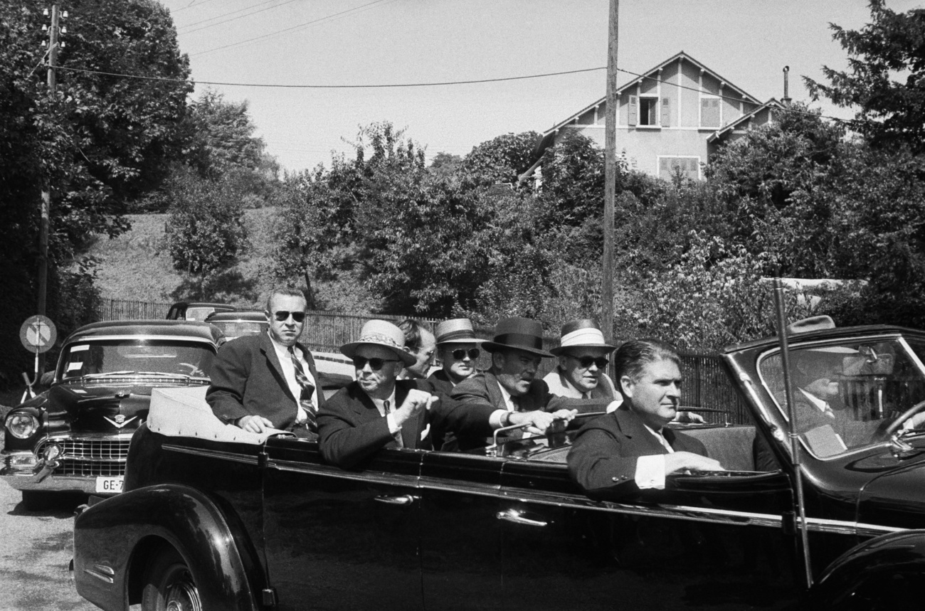 Participants Dwight Eisenhower, John Foster, Nikolai Bulganin, Nikita Khushtchev, Edgar Faure, Antoine Pinay, Anthony Eden, Harold Macmillan and FBI agents with sun-goggles and typical hats.