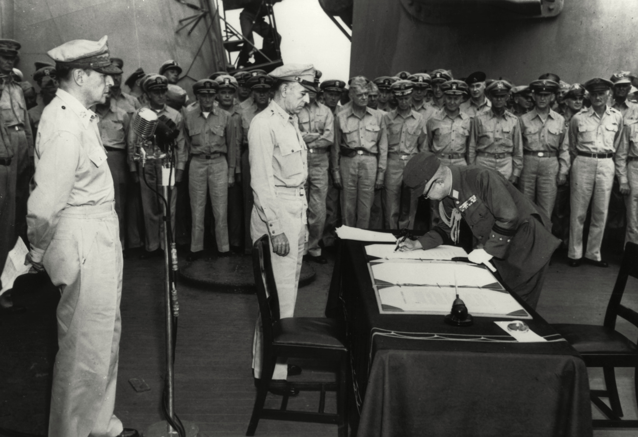 men signing document in black-and-white photo