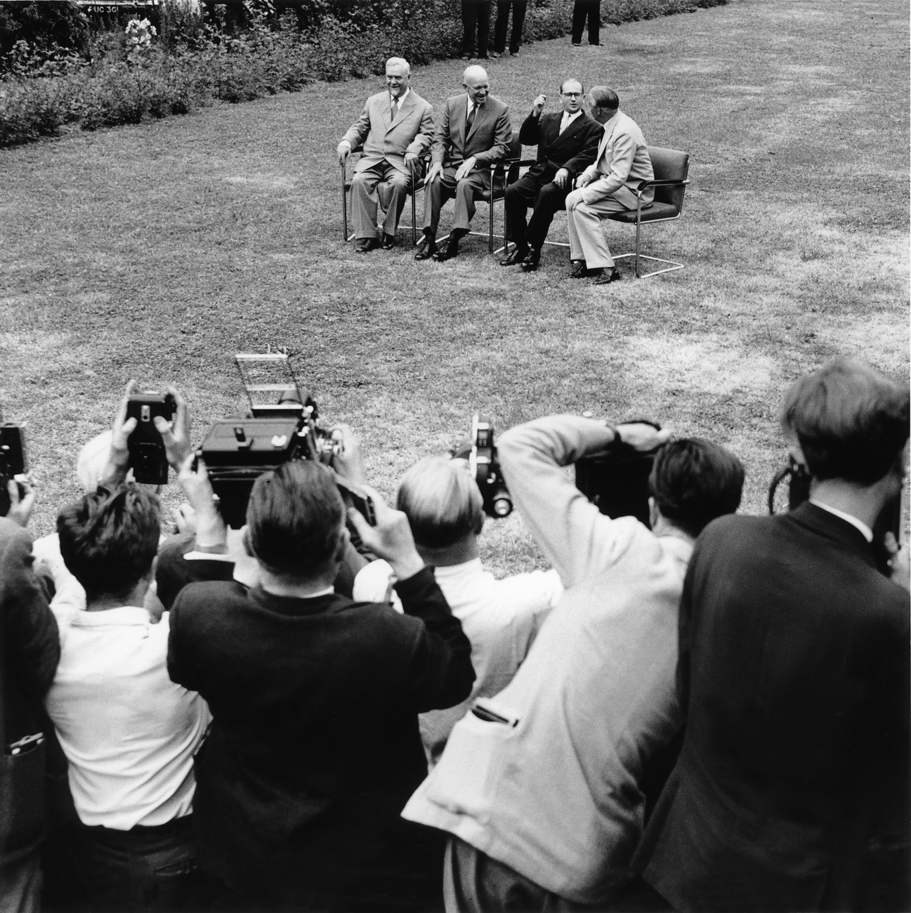 Nikolai Bulganin, Dwight D. Eisenhower, Edgar Faure und Anthony Eden sitzen nebeneinander auf Stühlen und werden fotografiert.