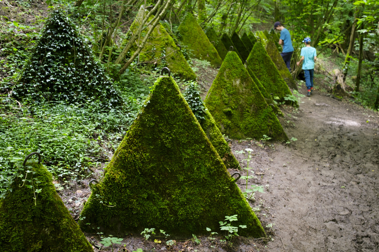 徒步者在贝尼尼(Begnins)的“三角巧克力之路”上绕过重达九吨的混凝土障碍块。