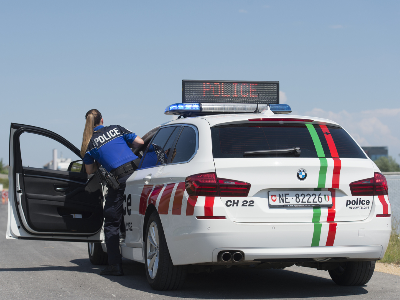 poliziotta esce da auto della polizia di neuchatel