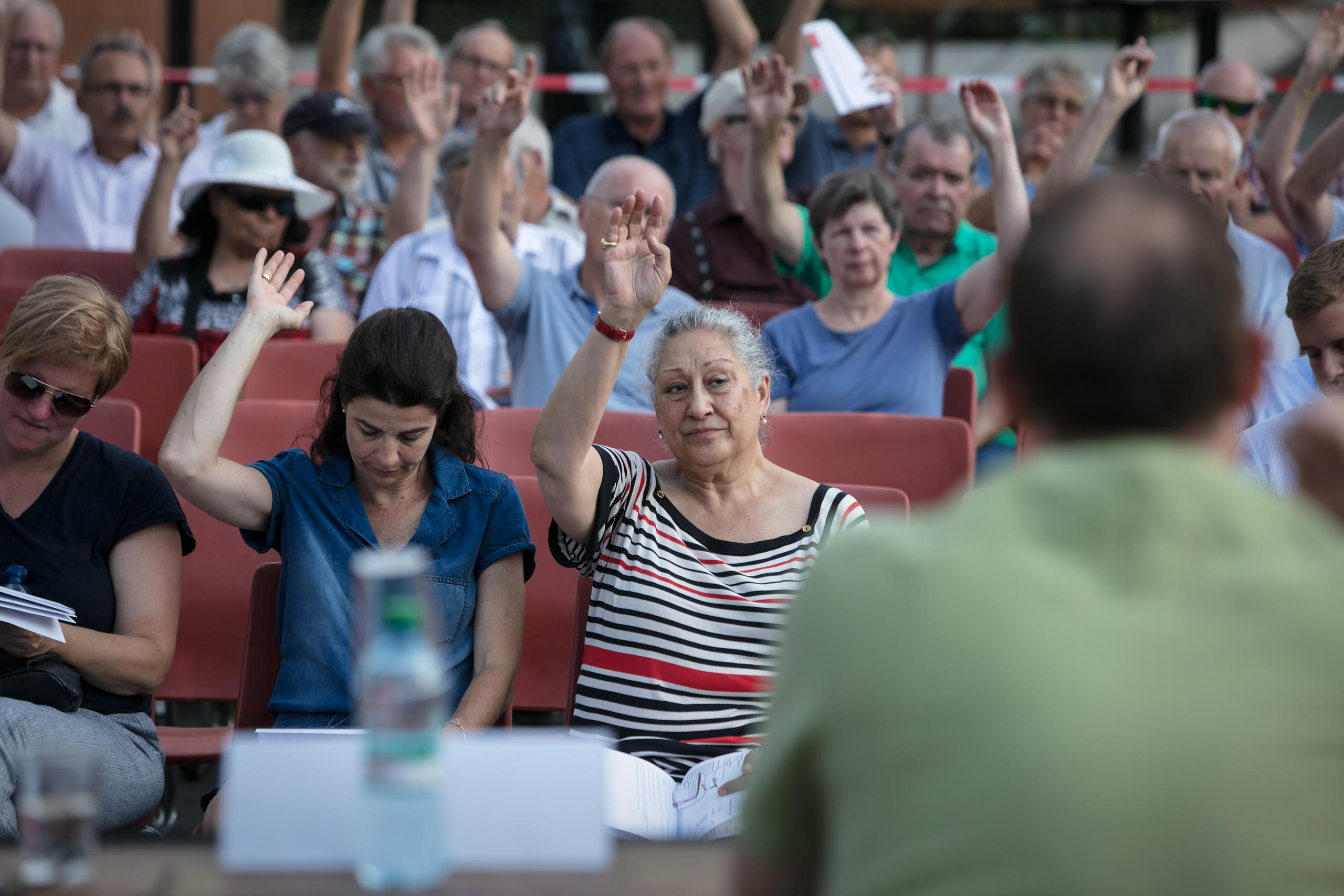 persone alzano la mano