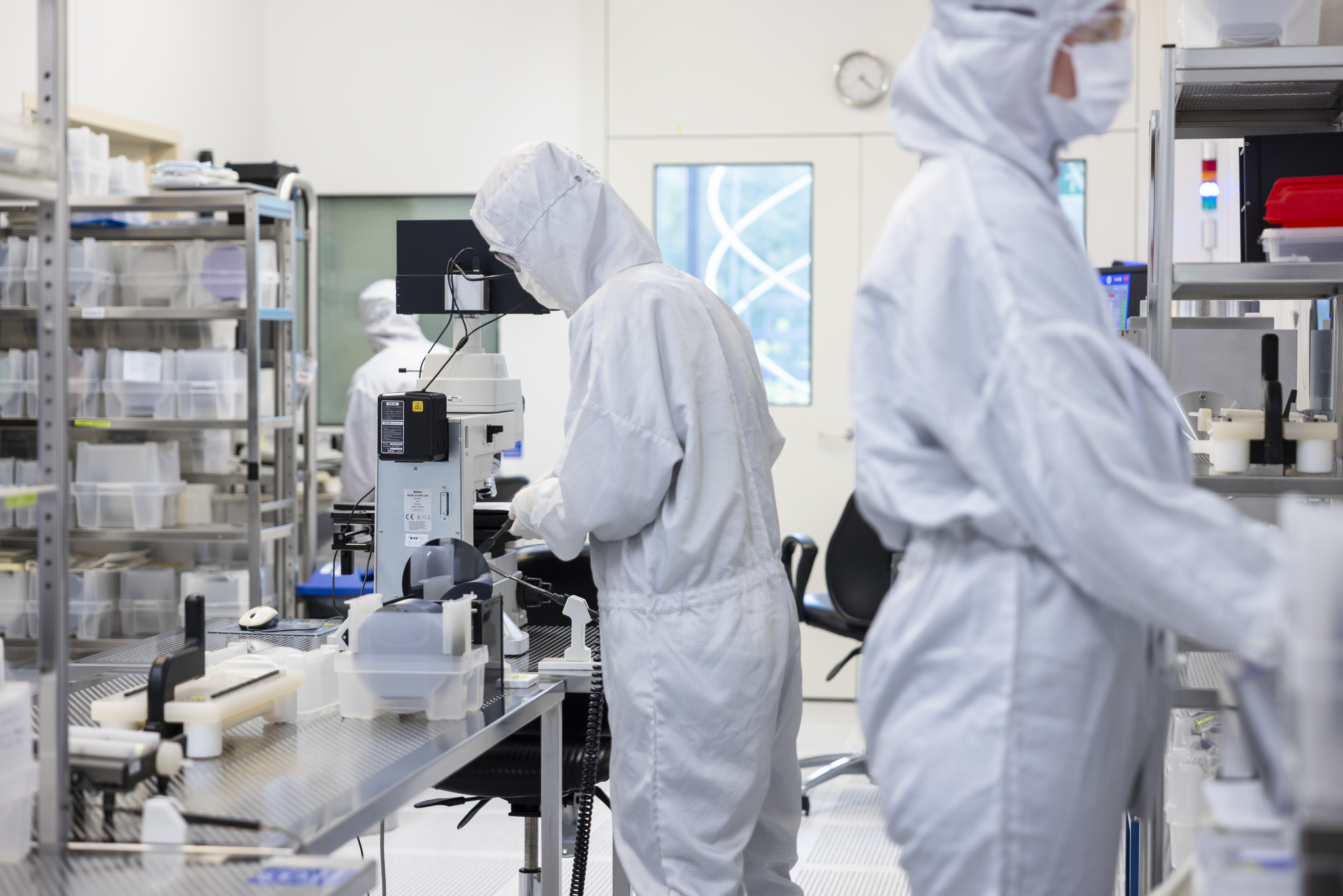 Zwei Personen in weissen Schutzanzügen in einem Labor