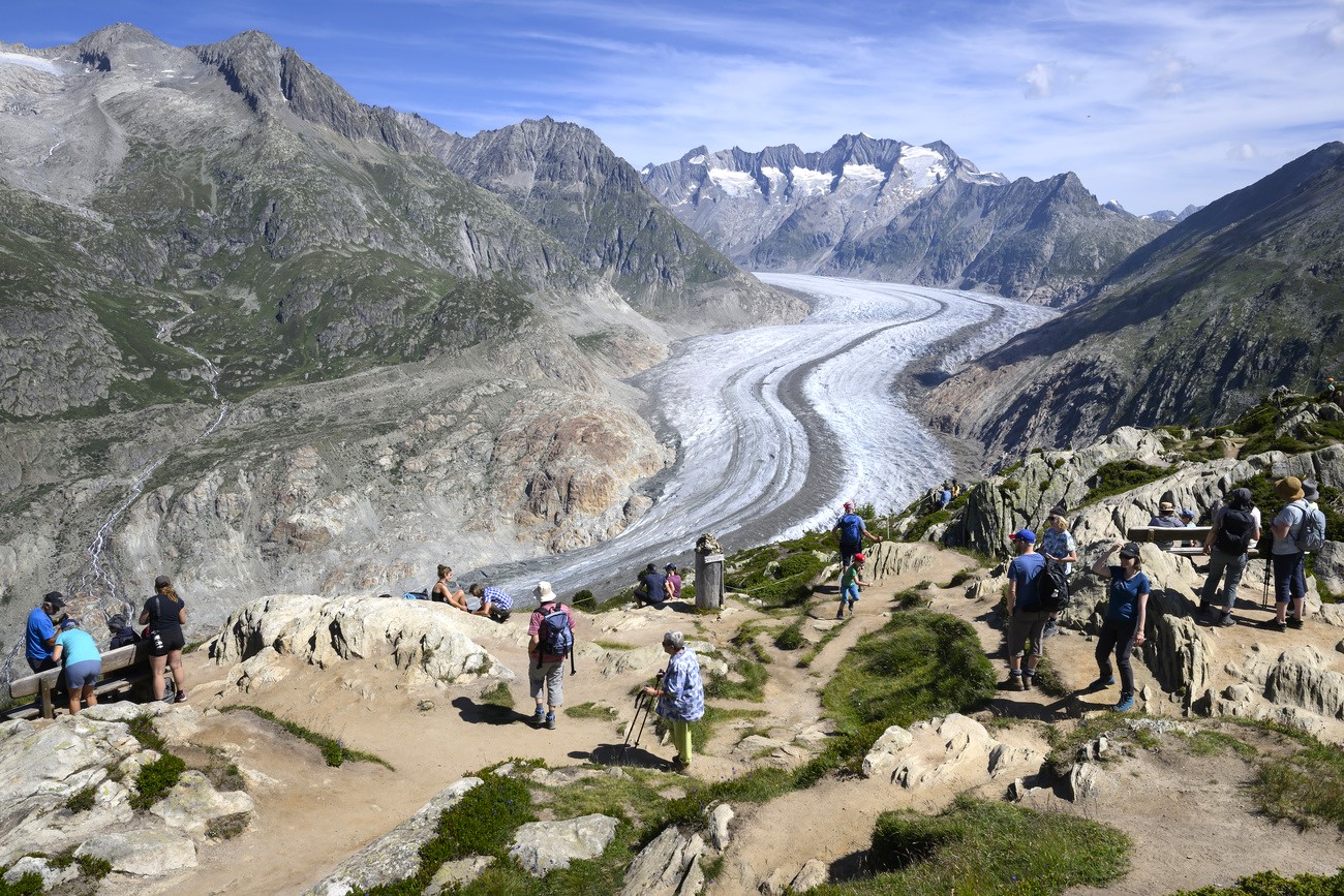 Tourists admire the Aletsch Glacier, the longest glacier in Europe.