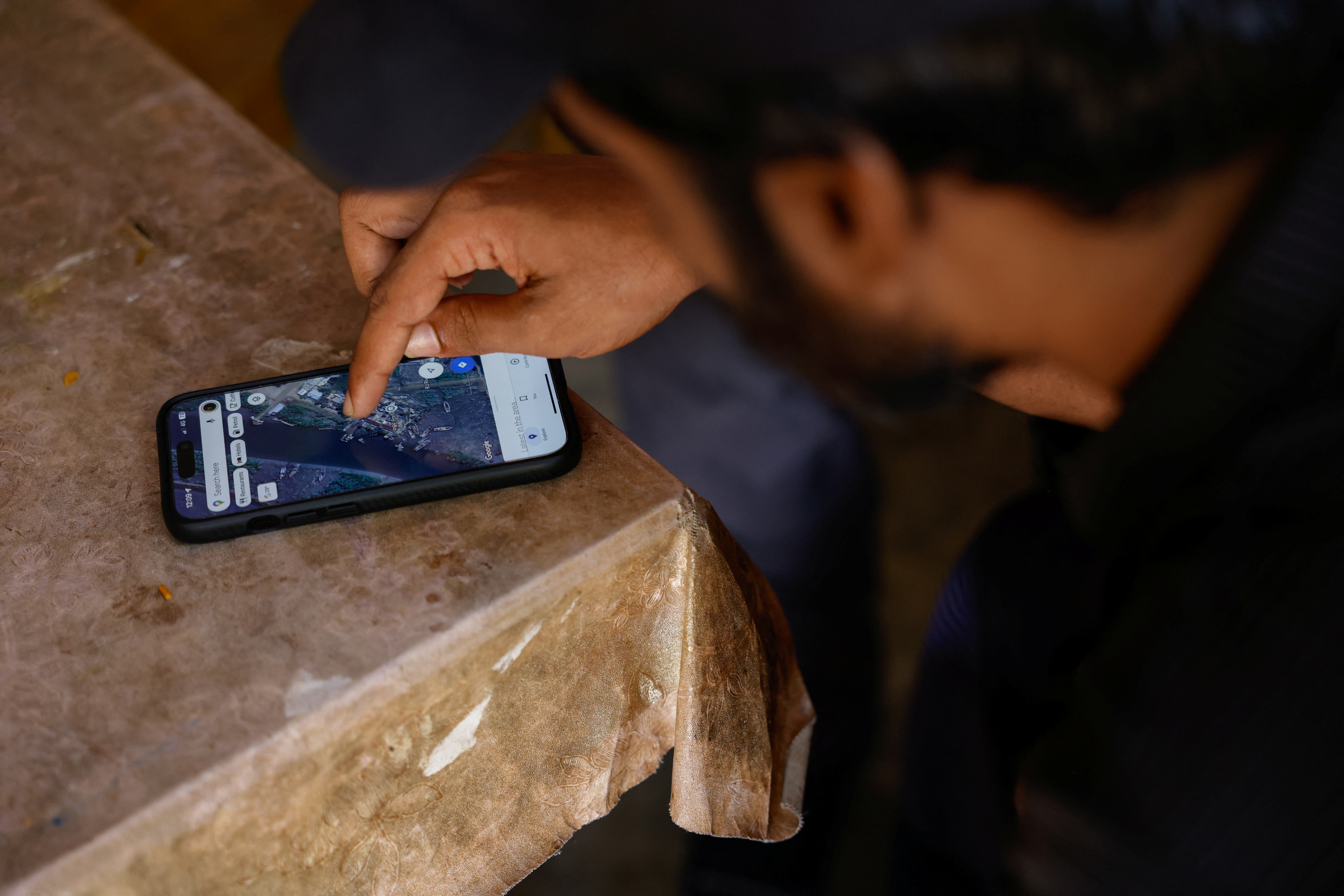 Ein Mann zeigt eine Karte von Myanmar auf seinem Smartphone