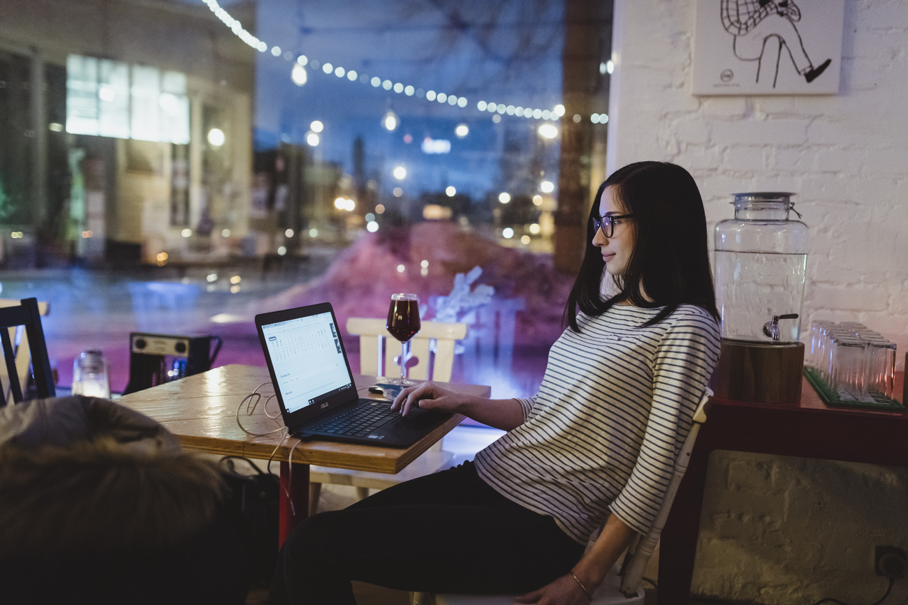 una donna con un laptop acceso su un tavolo di un ristorante