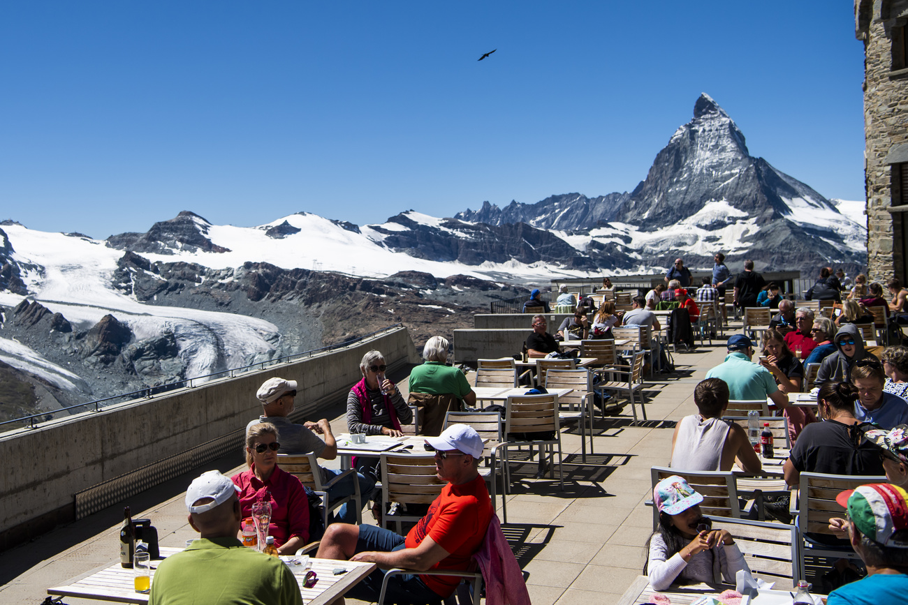 Menschen auf einer Terasse mit Blick auf das Matterhorn