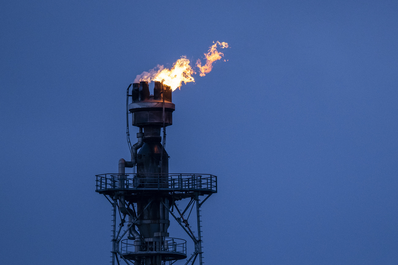 Chamas saindo de uma chaminé em uma refinaria.