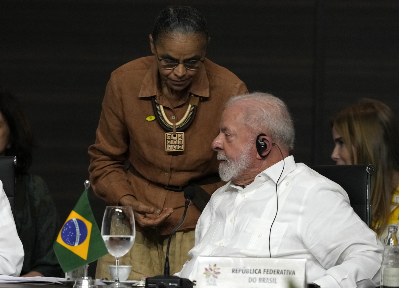 O presidente Lula, sentado, e a ministra do Meio Ambiente, Marina Silva.