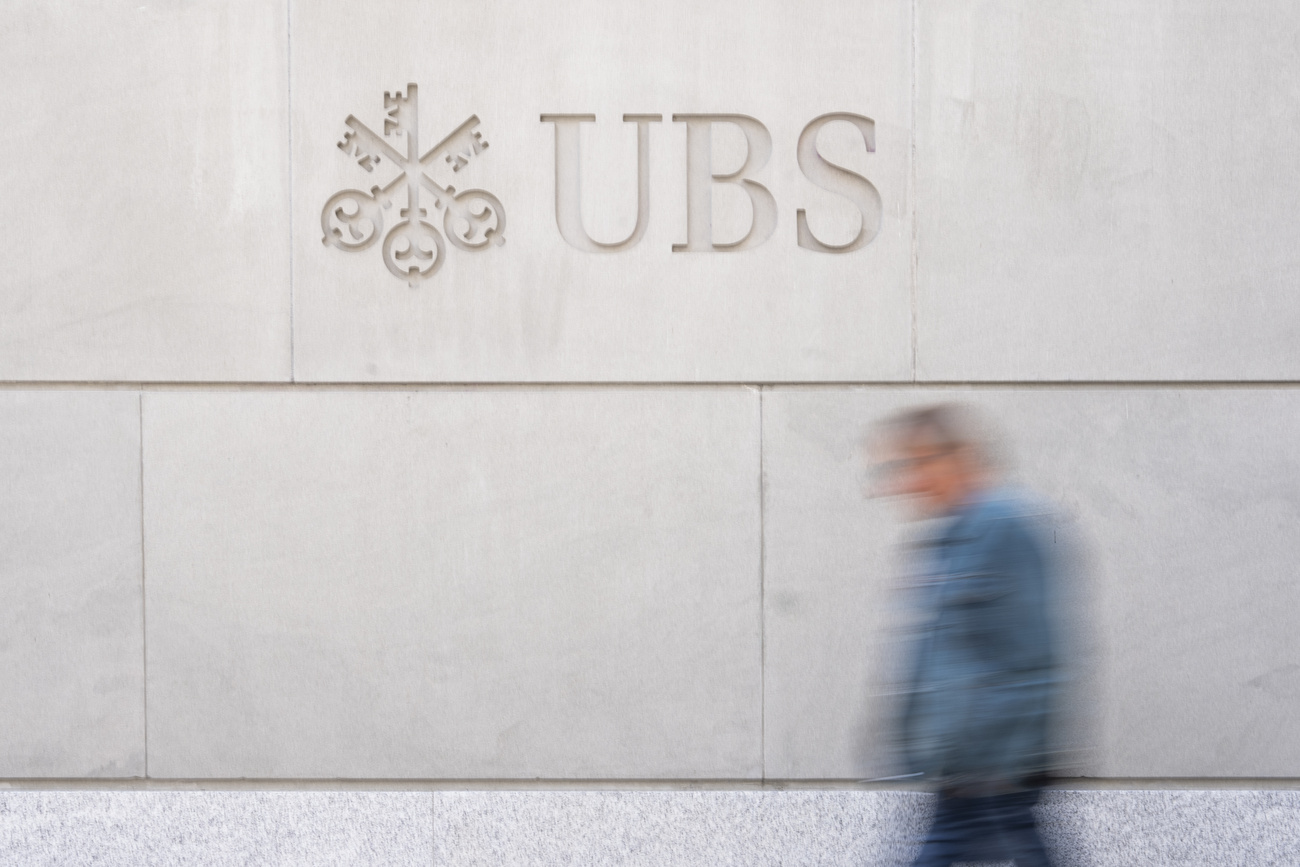 figure walking past UBS logo