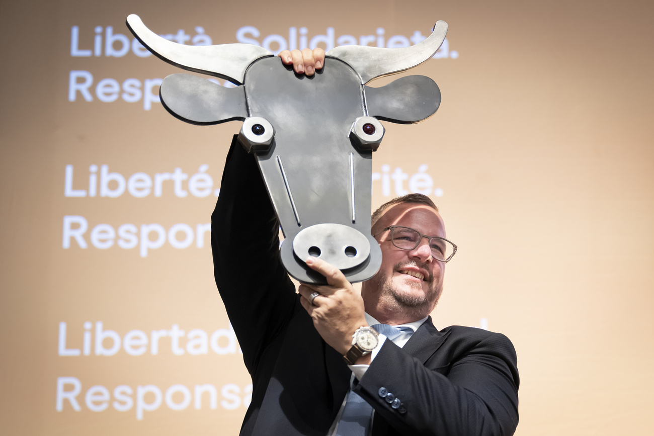 Philipp Matthias Bregy solleva una scultura raffigurante una testa di mucca