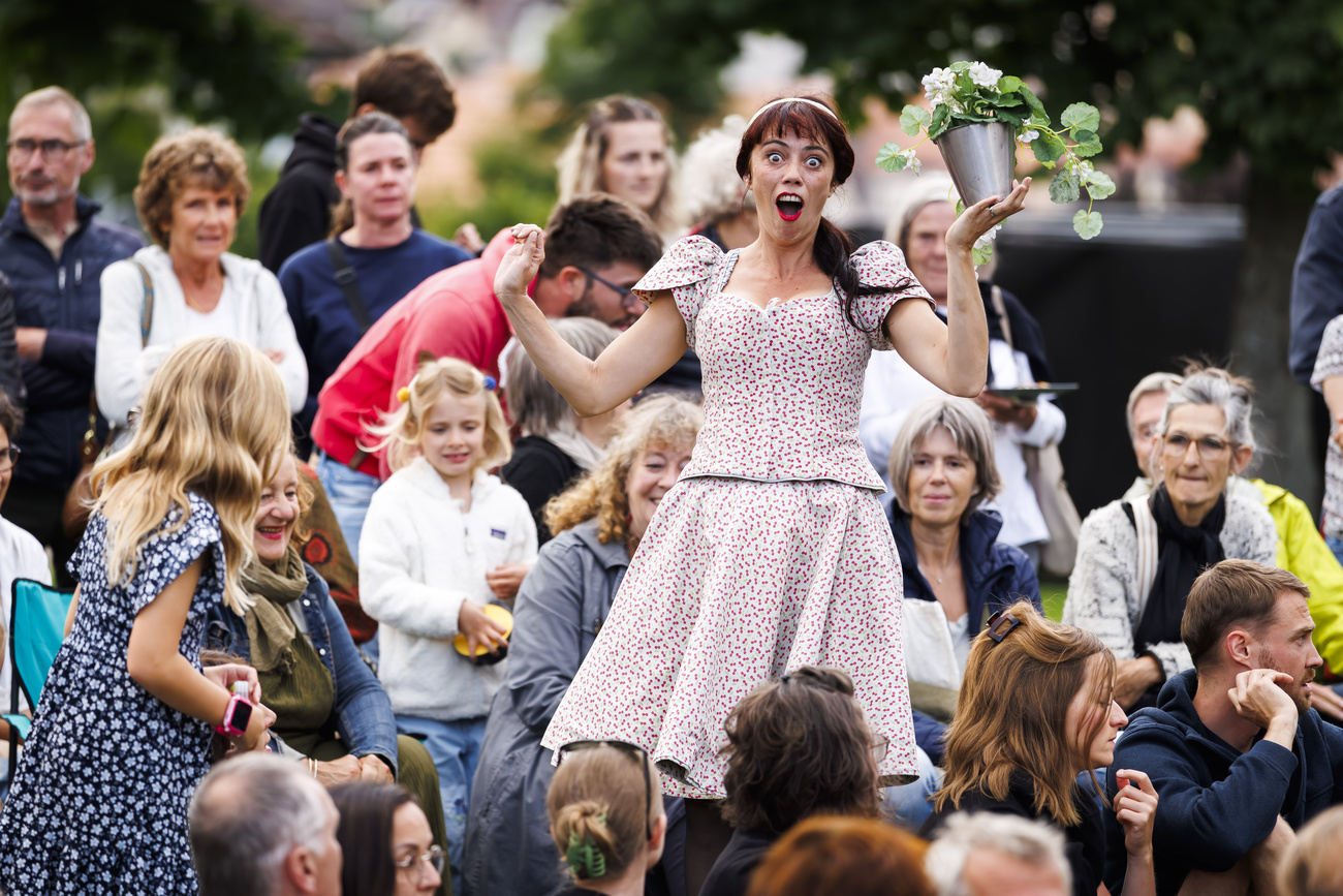 Eine Frau schauspielert mitten in einer Menschenmenge