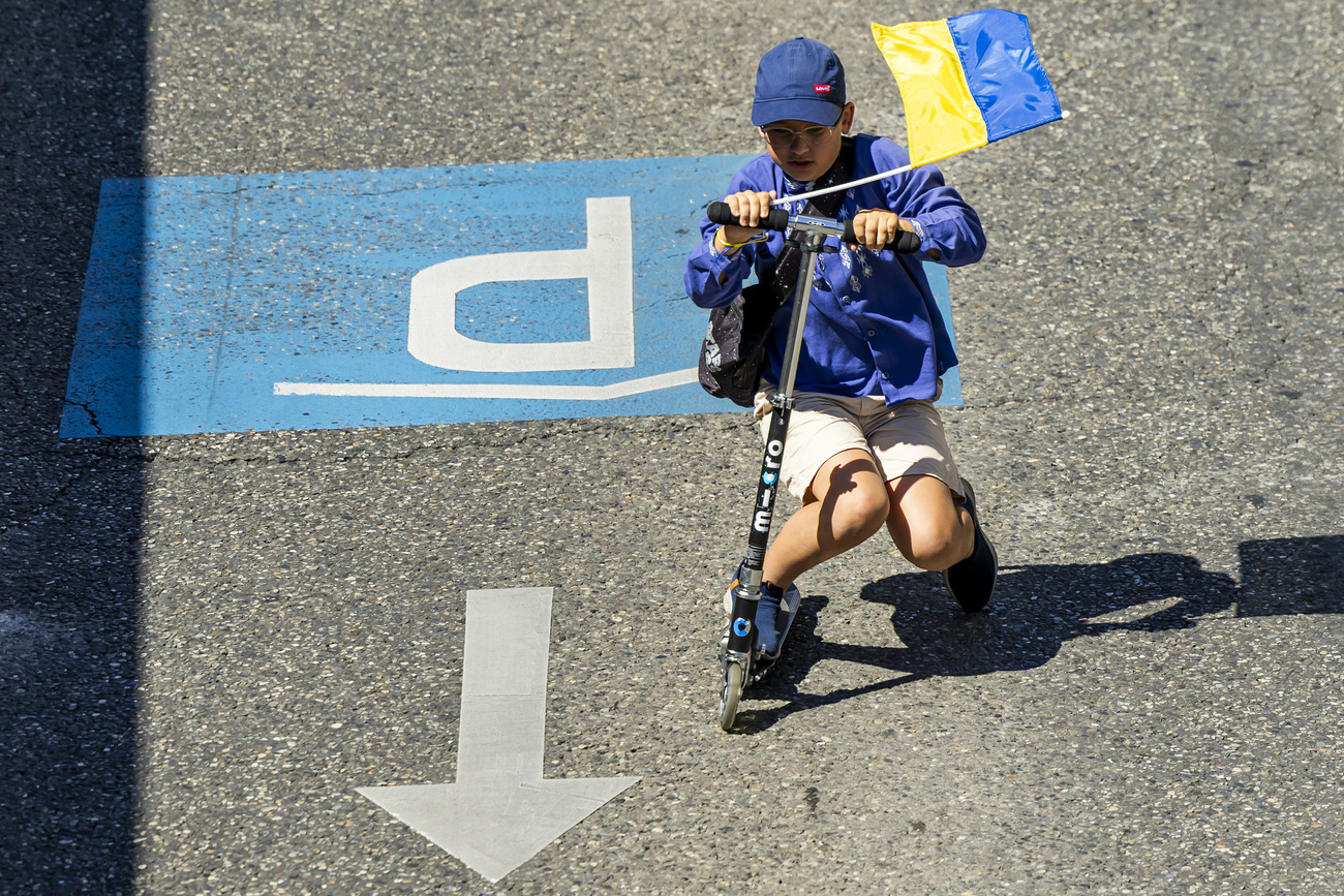 Un bambino sventola la bandiera nazionale ucraina durante una manifestazione organizzata per celebrare la festa dell'indipendenza dell'Ucraina, domenica a Ginevra.