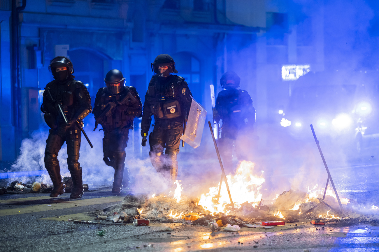 agenti tra le fiamme in strada
