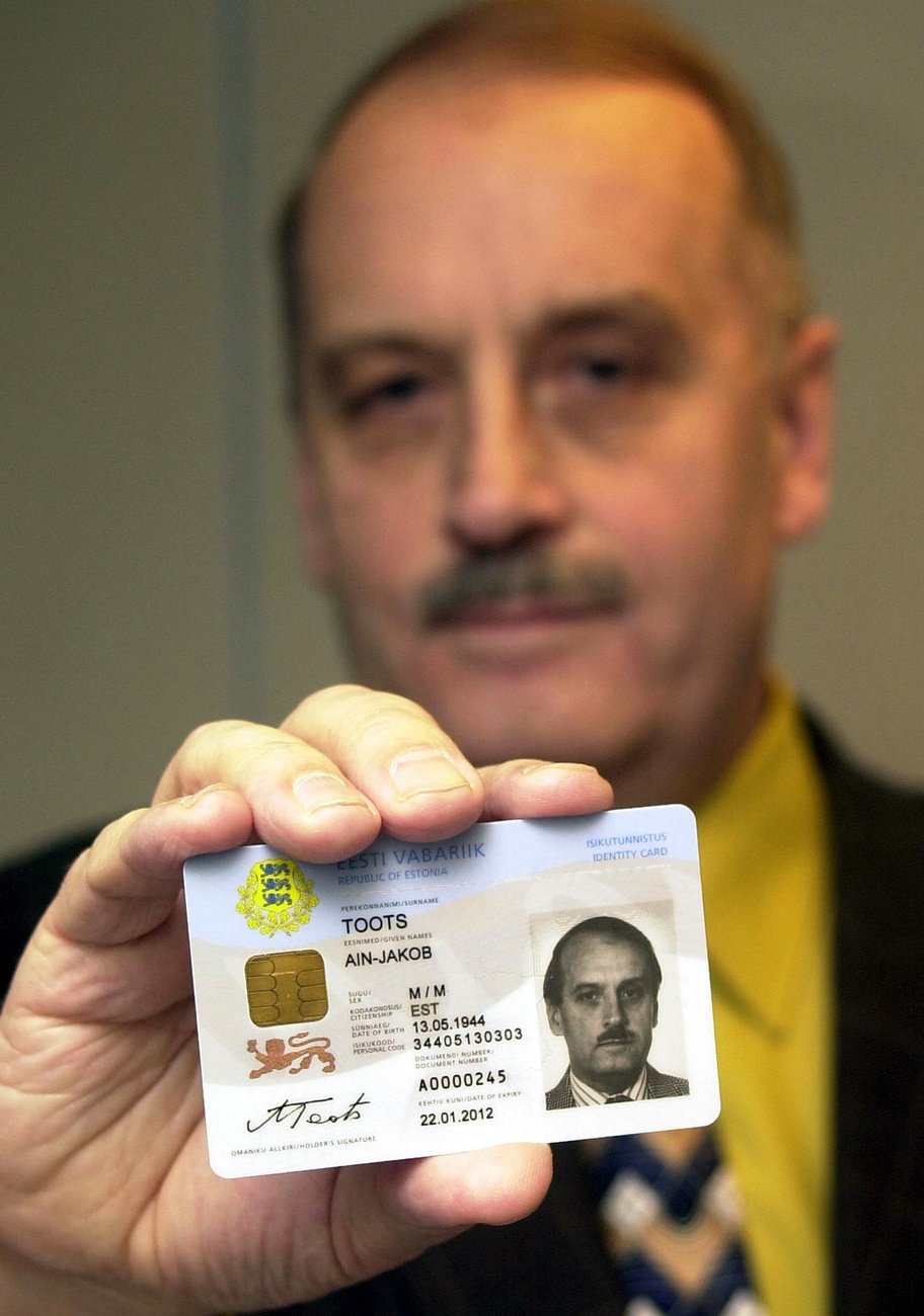 Este hält seine ID in die Kamera.