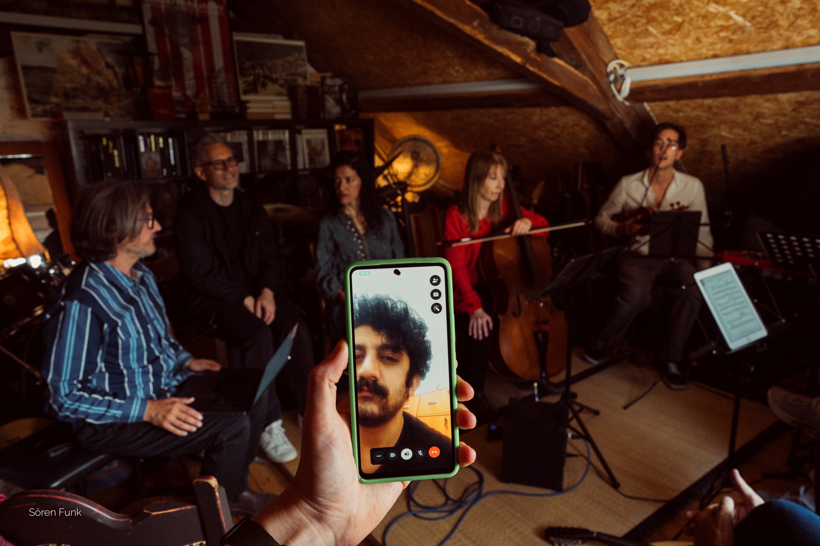 Mehdi Rajabian (face on the phone) accompanies a rehearsal of the Zurich ensemble from his home in Teheran.