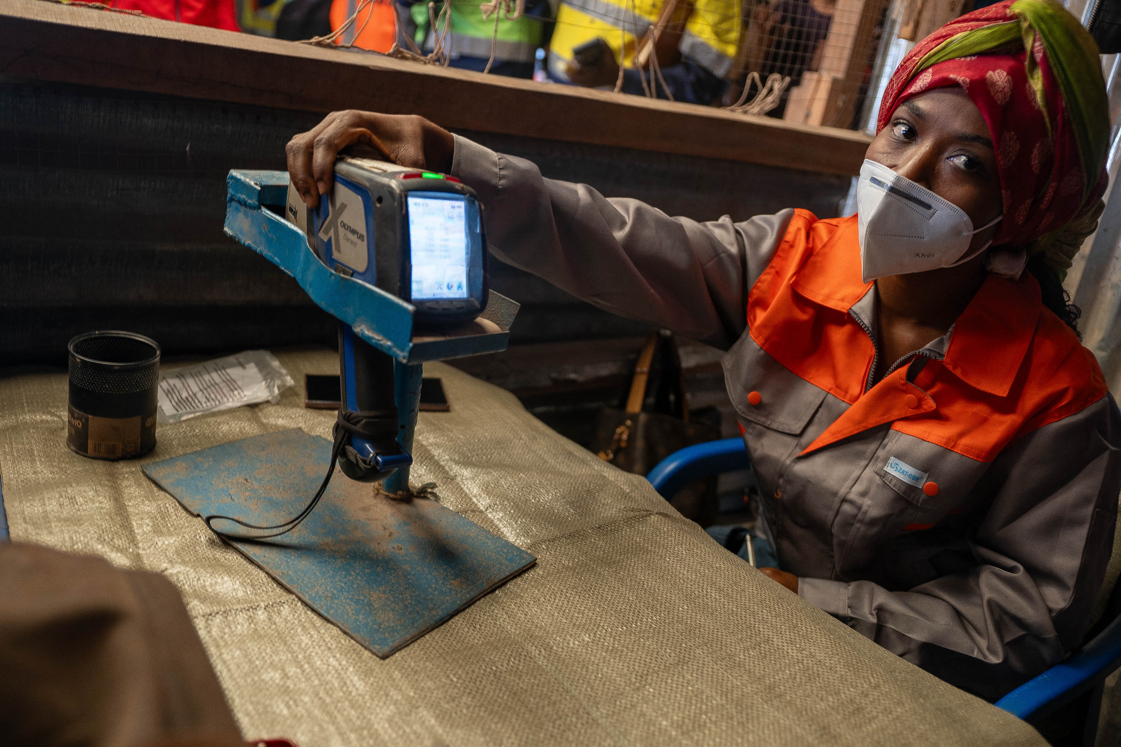 Une femme montre un pistolet XRF utilisé pour déterminer la pureté du minerai dans un dépôt commercial de la mine artisanale de cuivre-cobalt de Kamilombe, près de la ville de Kolwezi, dans le sud-est de la République démocratique du Congo