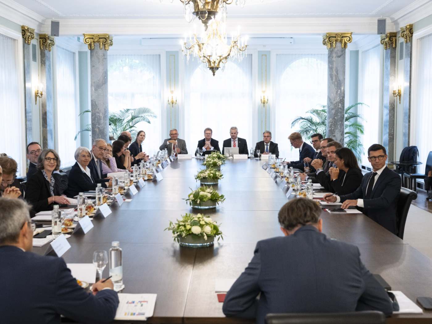 politici e rappresentanti dell'industria farmaceutica seduti intorno a un tavolo gigante