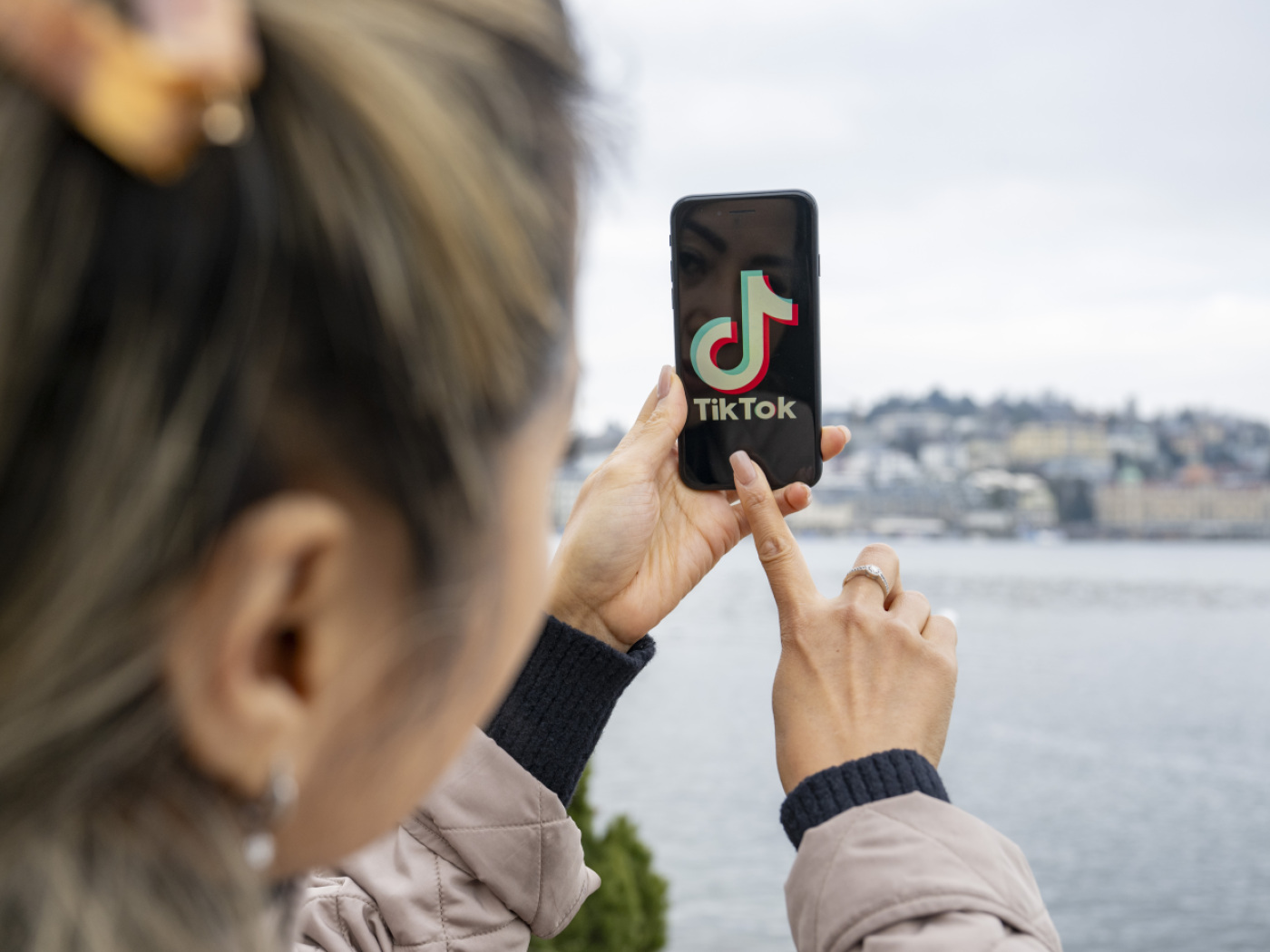 persona con cellulare in mano fotografa un panorama mentre sullos chermo appare il logo di tik tok