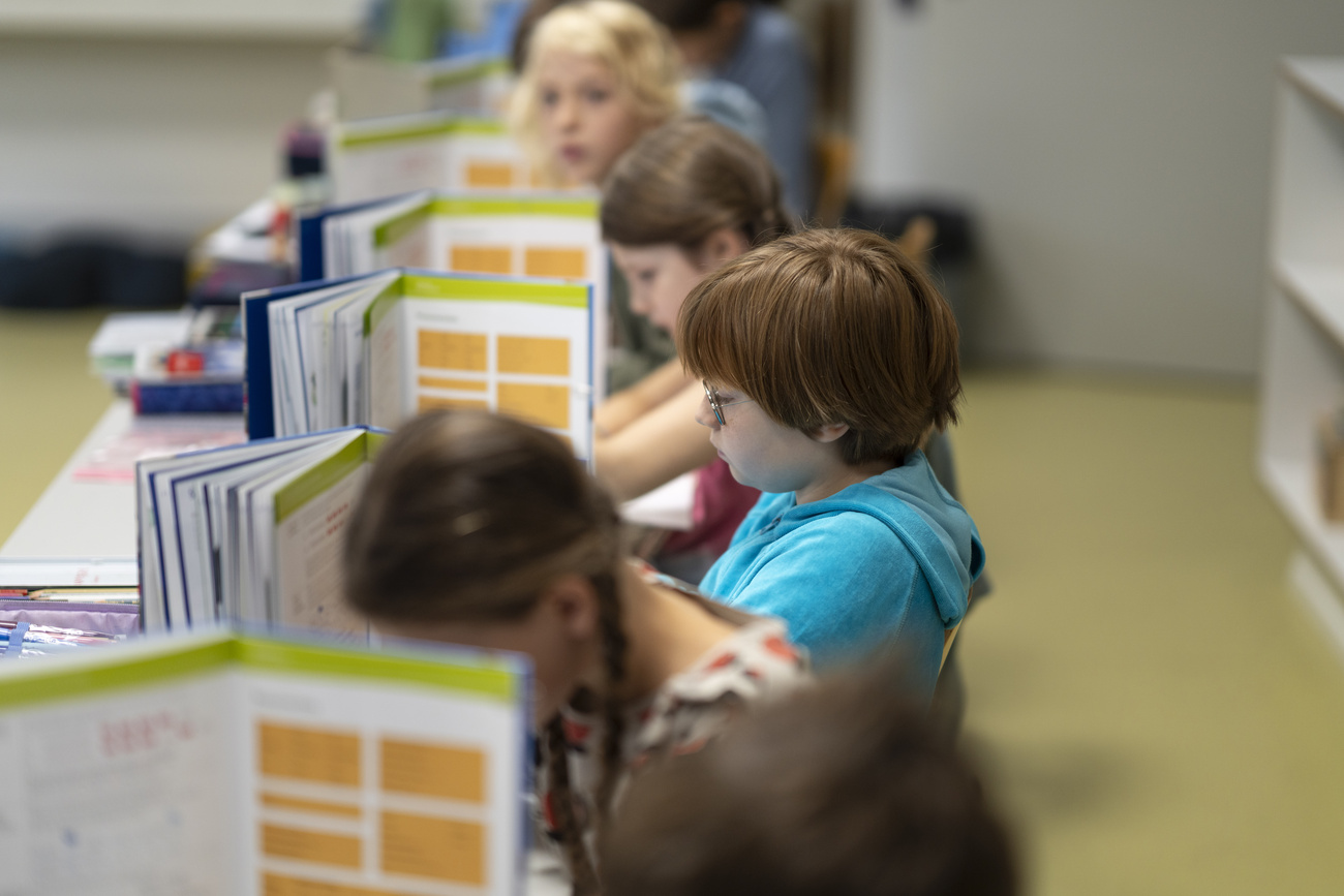 bambini nei banchi di scuola durante un test scritto