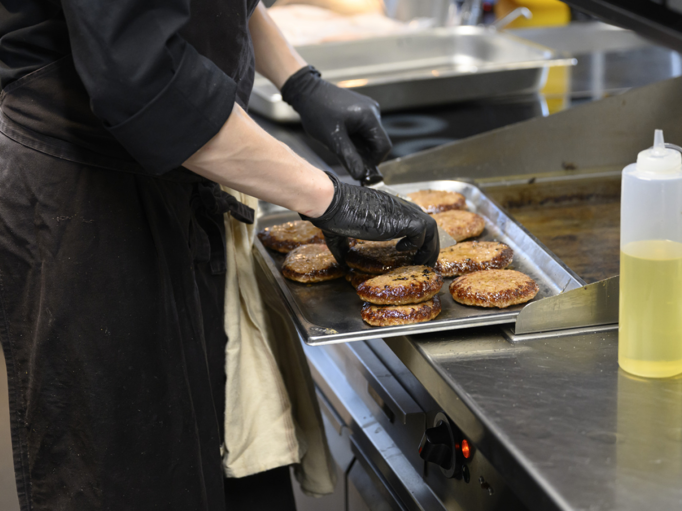 cuoco davanti a vassoio con hamburger