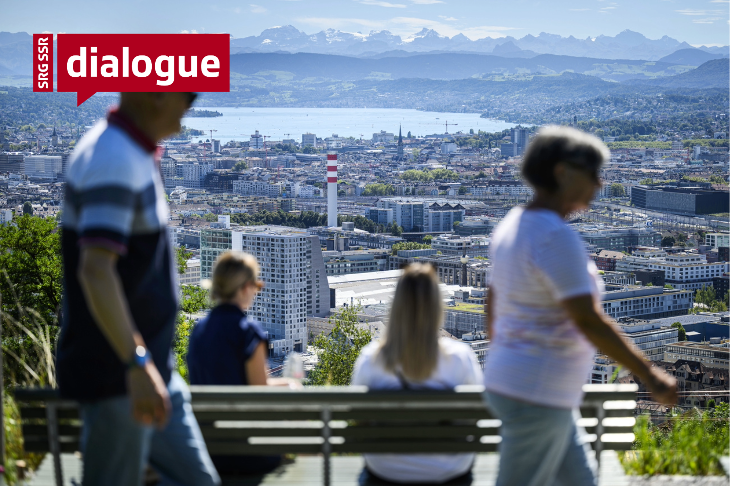 People overlooking lake of Zurich with mountains in the background