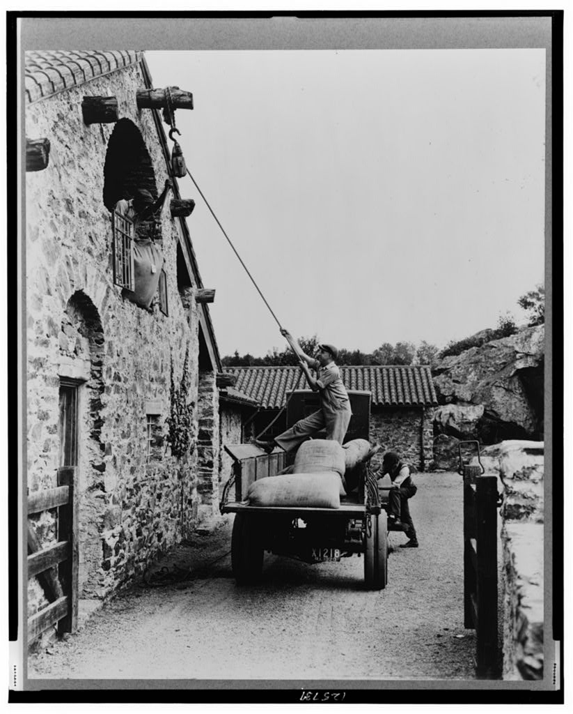 PErsone loads sacks into a barn