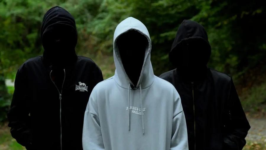 tre uomini incappucciati con il viso nascosto