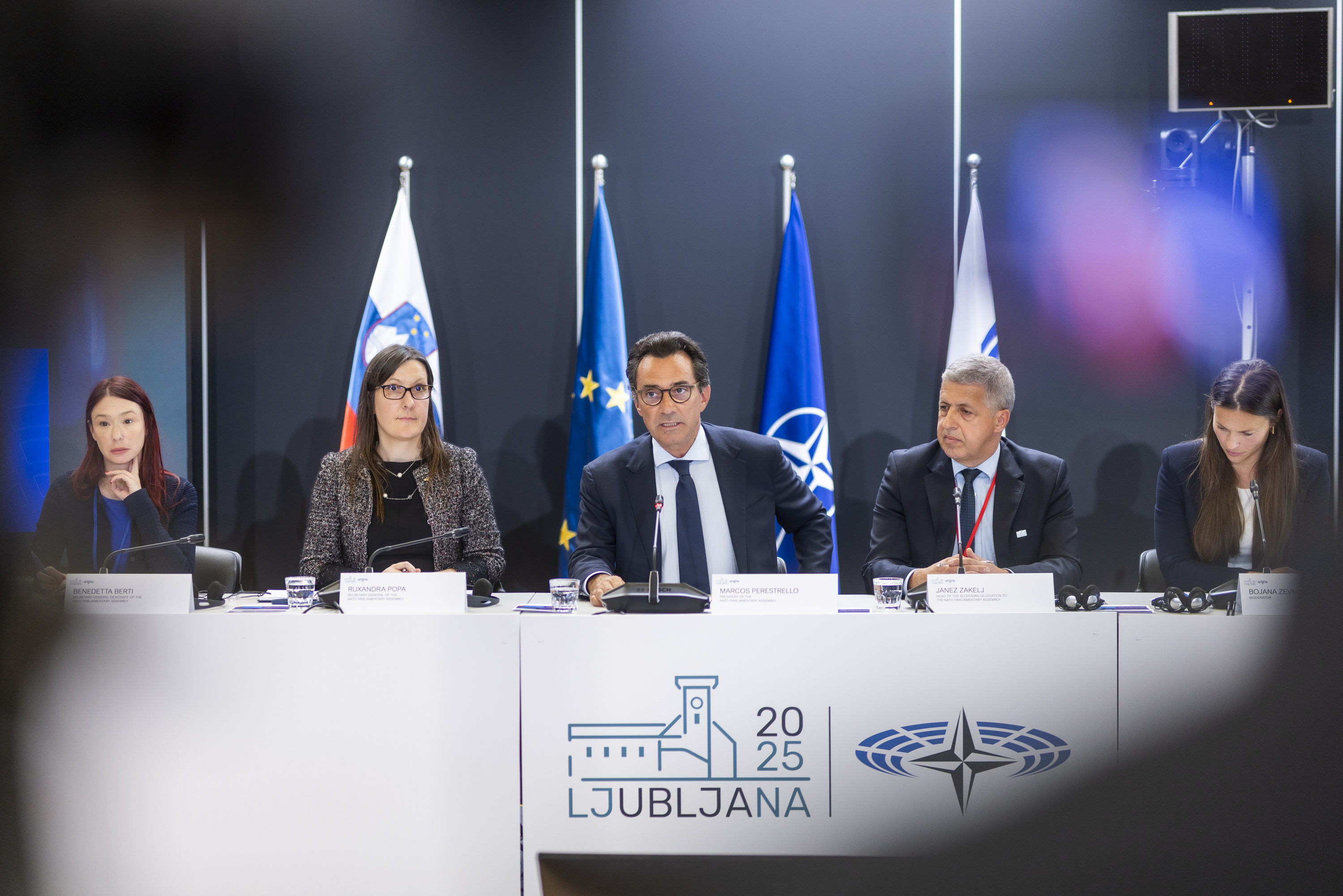press conference with five people in suits