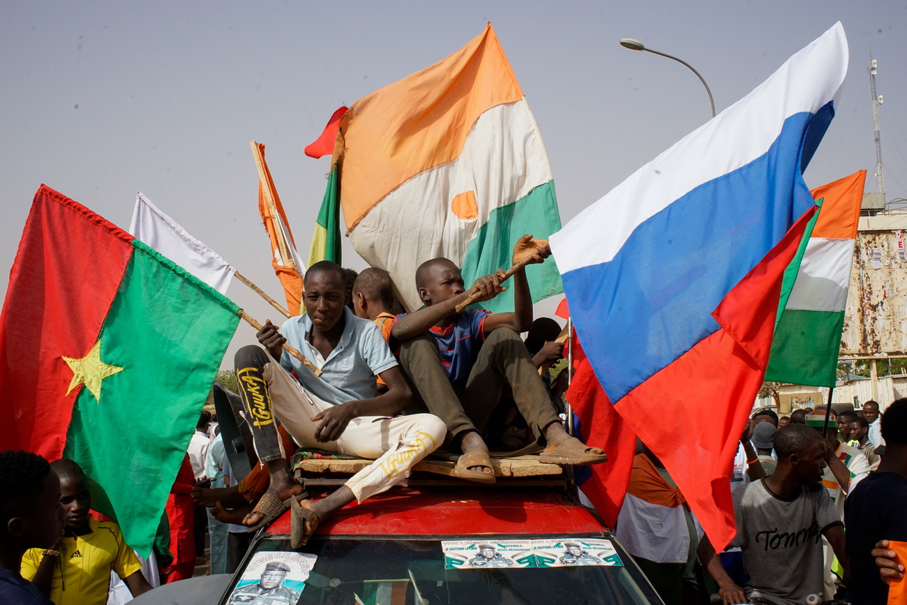 A group of people on a car with flags in their hands