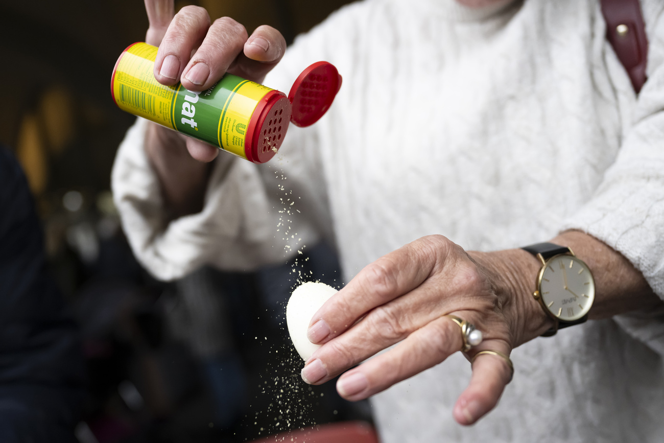 Persona spolvera dell'Aromat su un uovo sodo