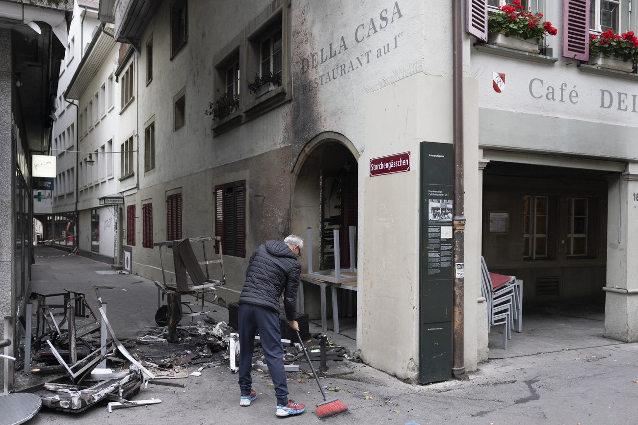 uomo spazza macerie