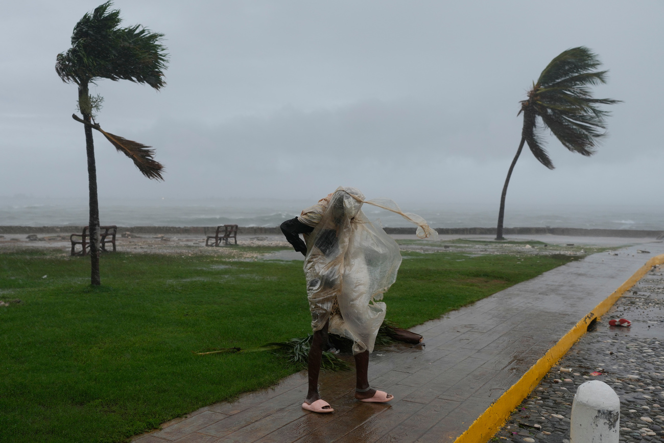 uomo con mantellina osserva mare in tempesta