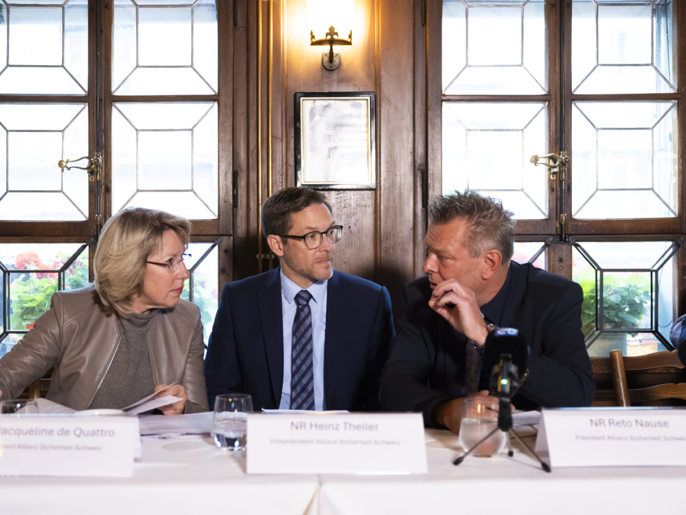 uomo pulisce detriti davanti a un ristorante dopo una manifestazione