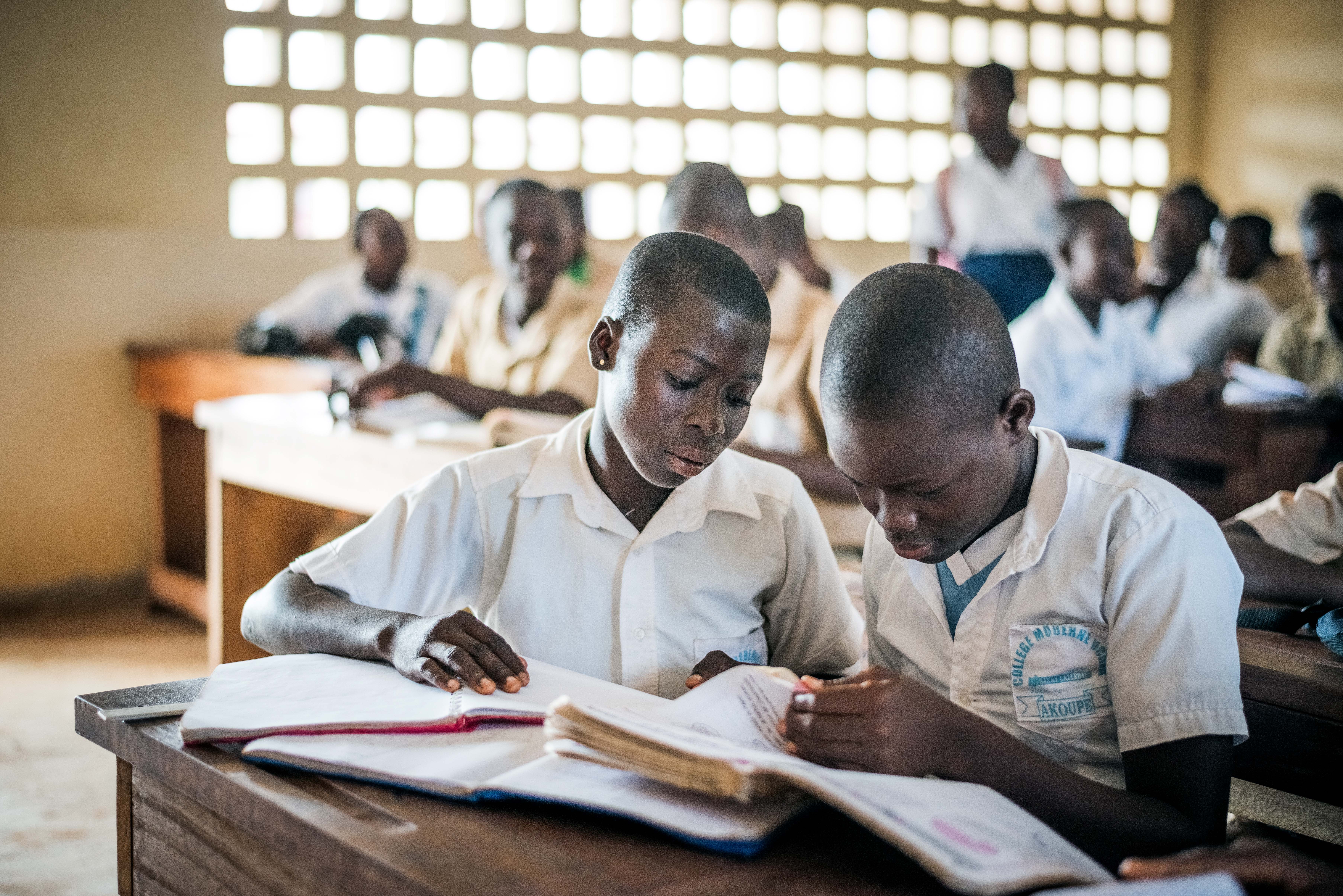 School children in Ivory Coast looking at a textbook.