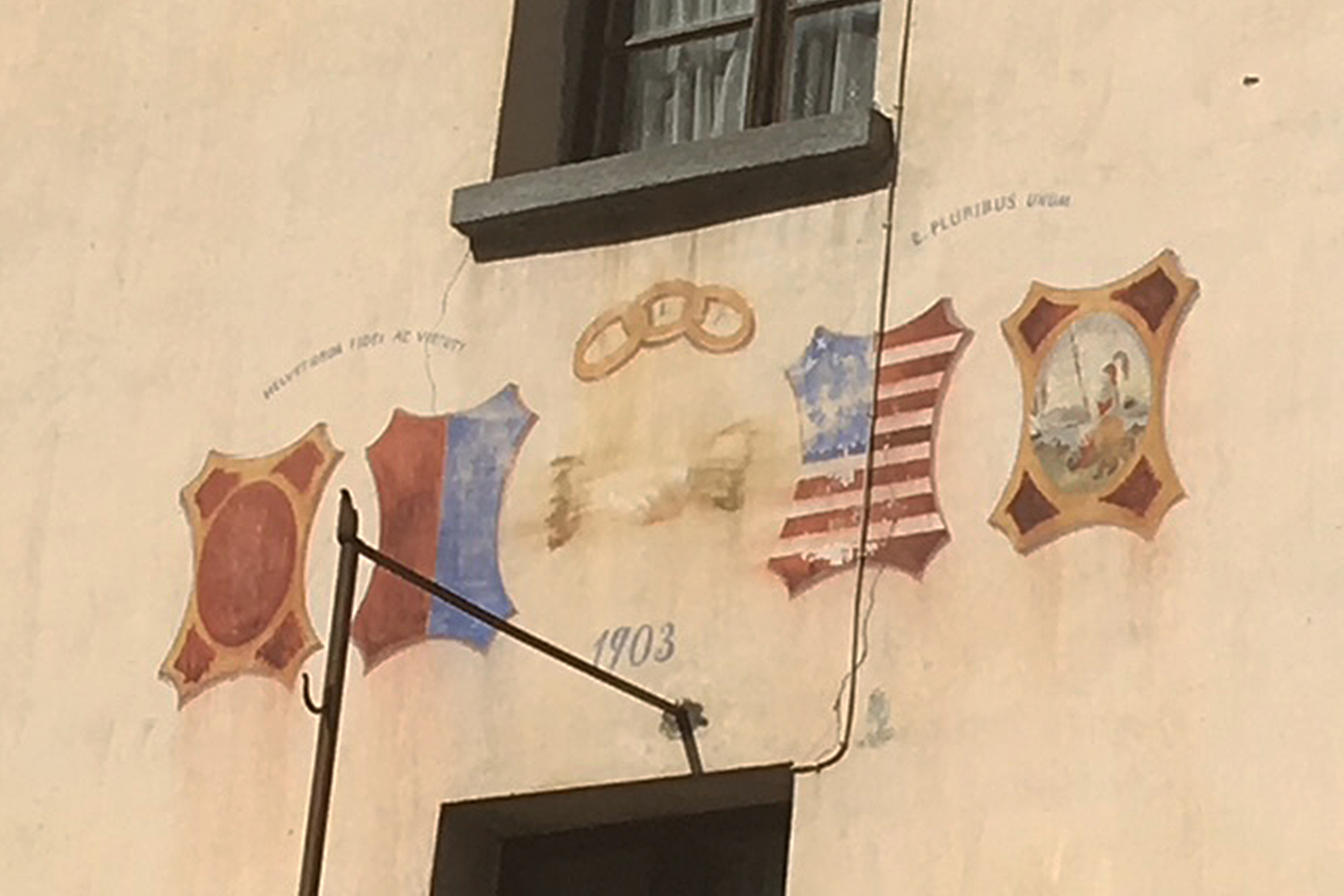 Hausseite mit Gemälden von Tessiner und amerikanischen Flaggen
