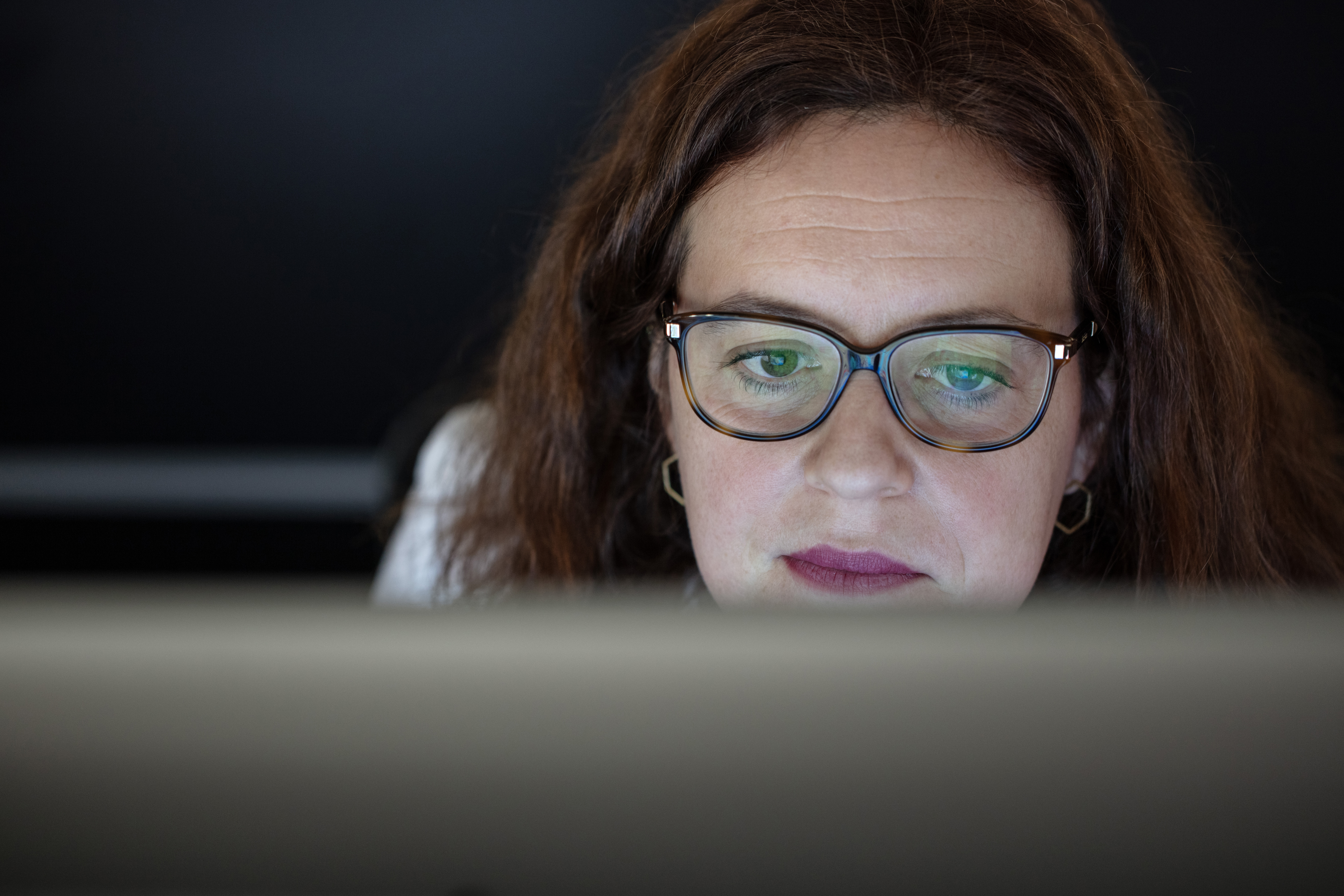 PCを覗く眼鏡の女性