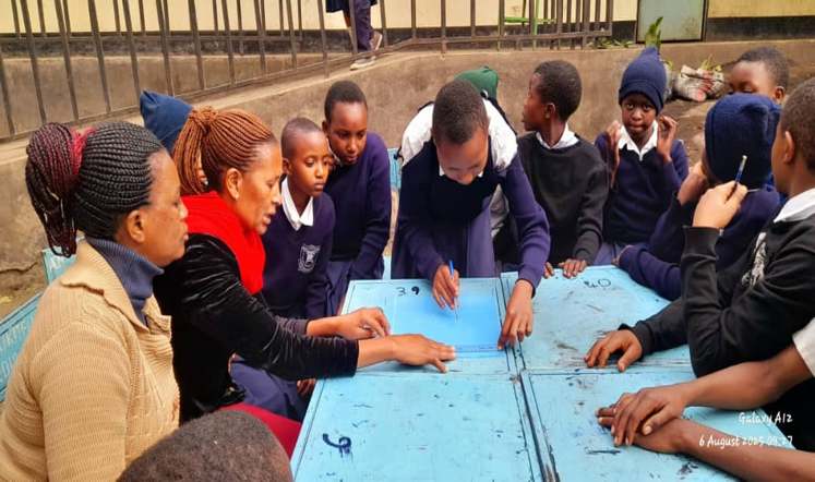 Teachers and pupils in schoolyard working on a project, in Arusha, Tanzania.